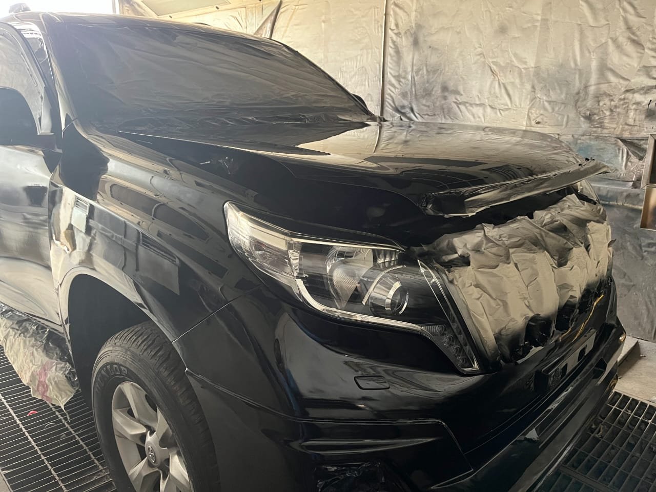 SUV masked for respray in the booth